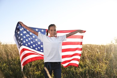 Photo of Happy girl with flag of USA outdoors