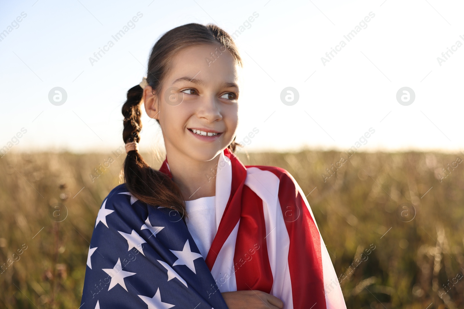 Photo of Happy girl with flag of USA outdoors