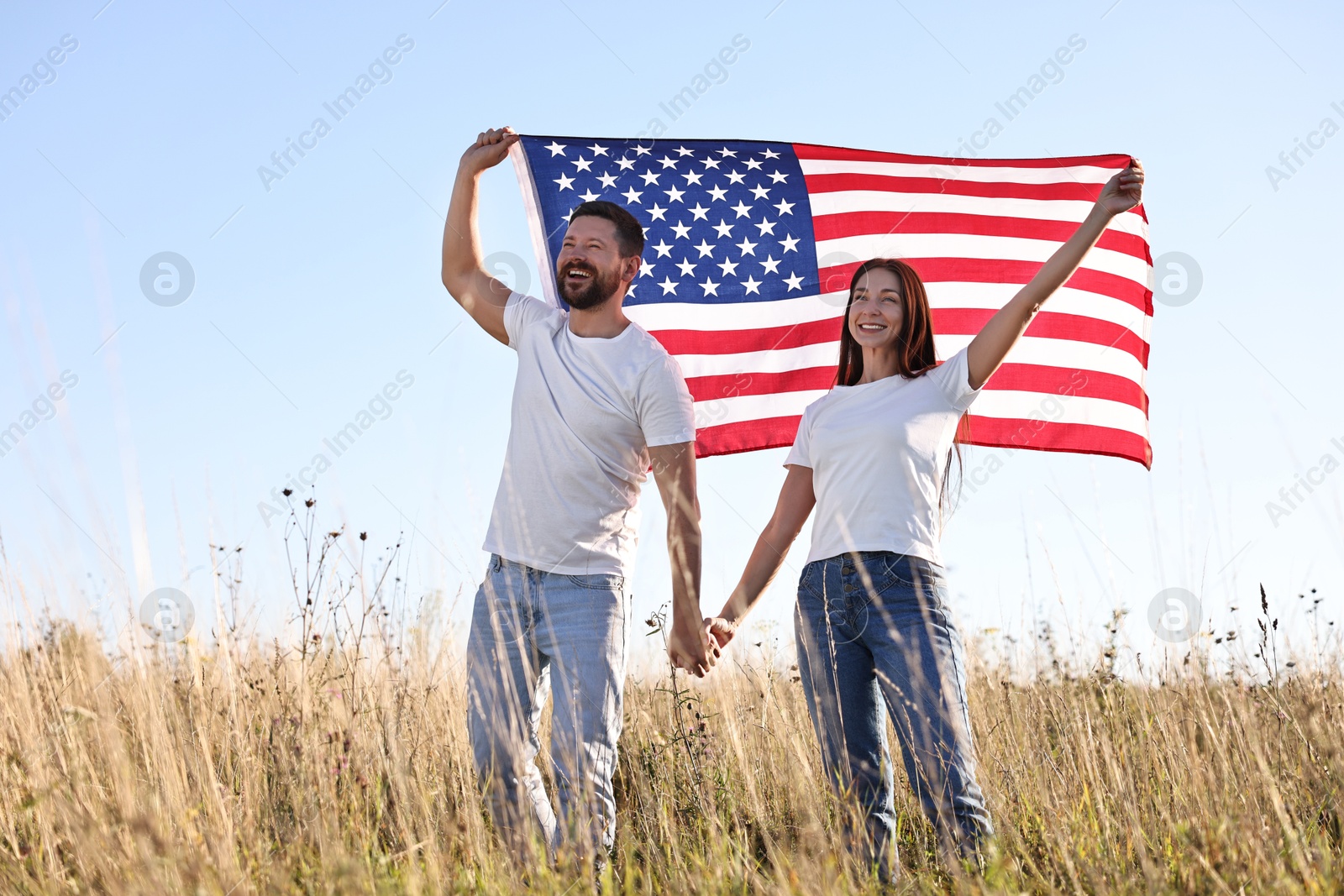 Photo of Happy couple with flag of USA outdoors