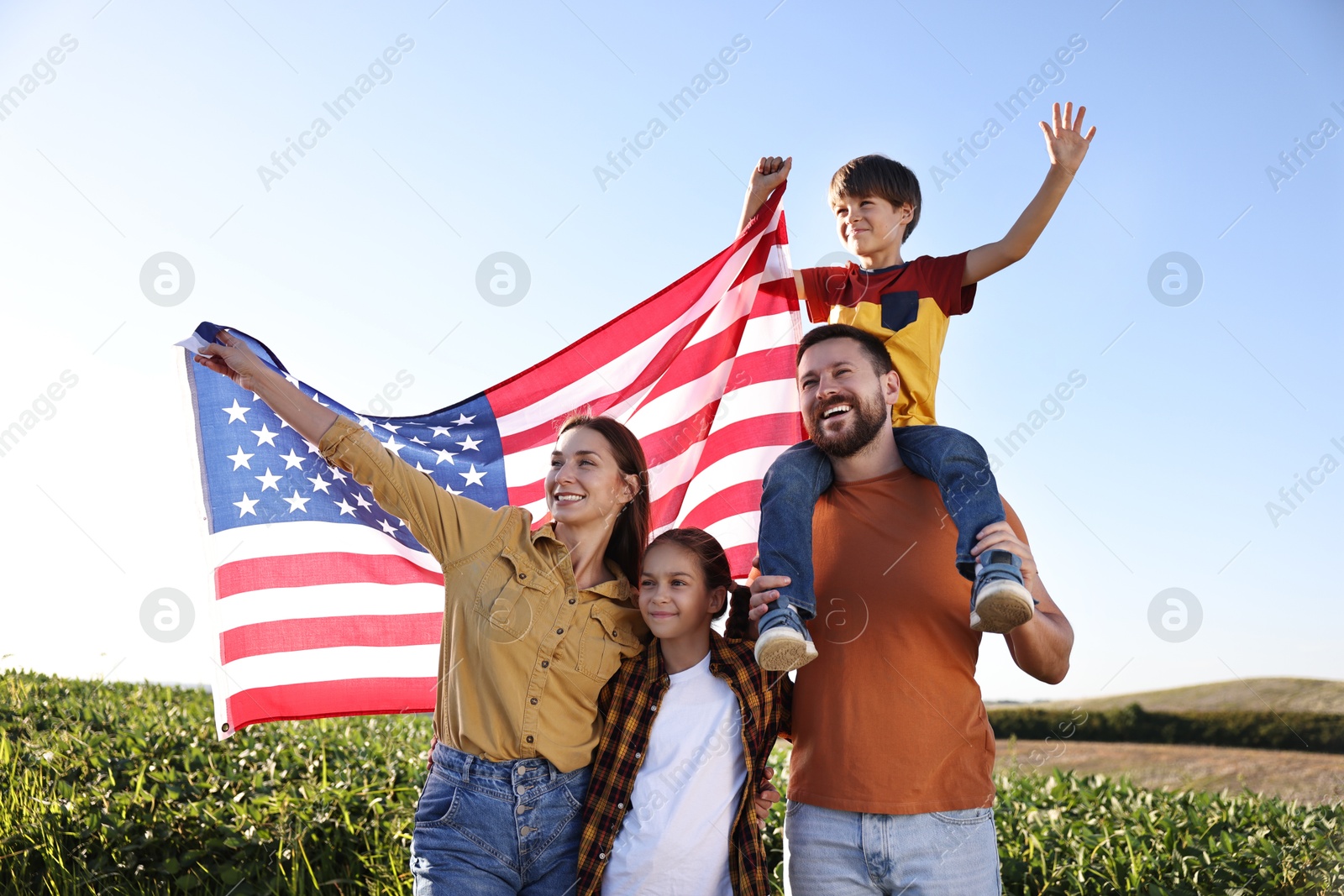 Photo of Happy family with flag of USA outdoors