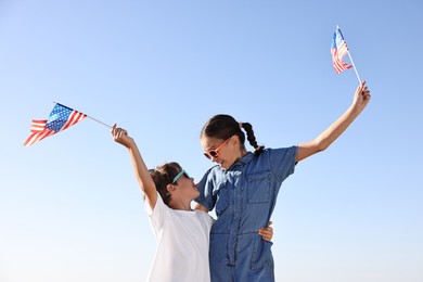 Photo of Brother and sister with flags of USA outdoors