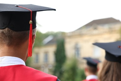 Students at graduation ceremony outdoors, back view