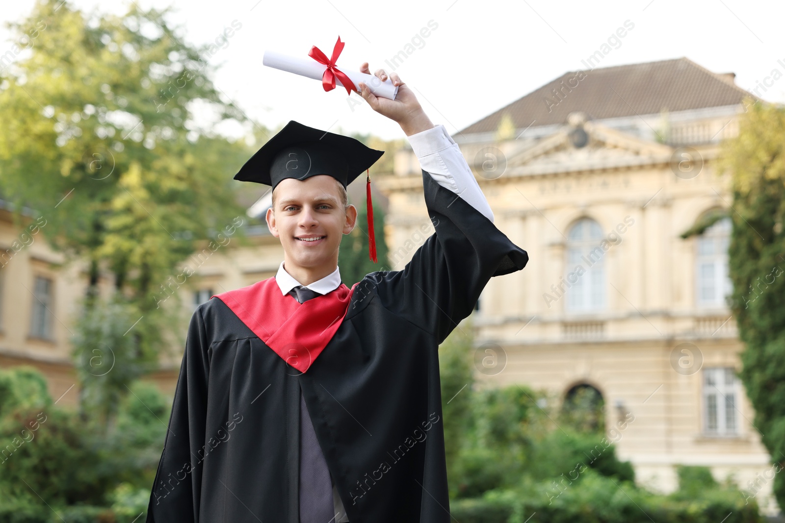 Photo of Happy student with diploma after graduation ceremony outdoors, space for text