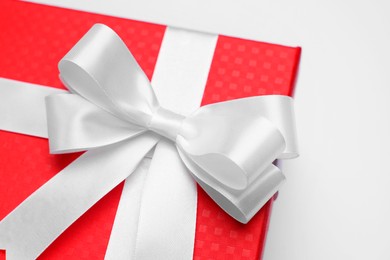 Photo of Gift box with bow on light grey background, closeup