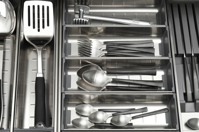 Photo of Cutlery in box, top view. Kitchen utensils storage