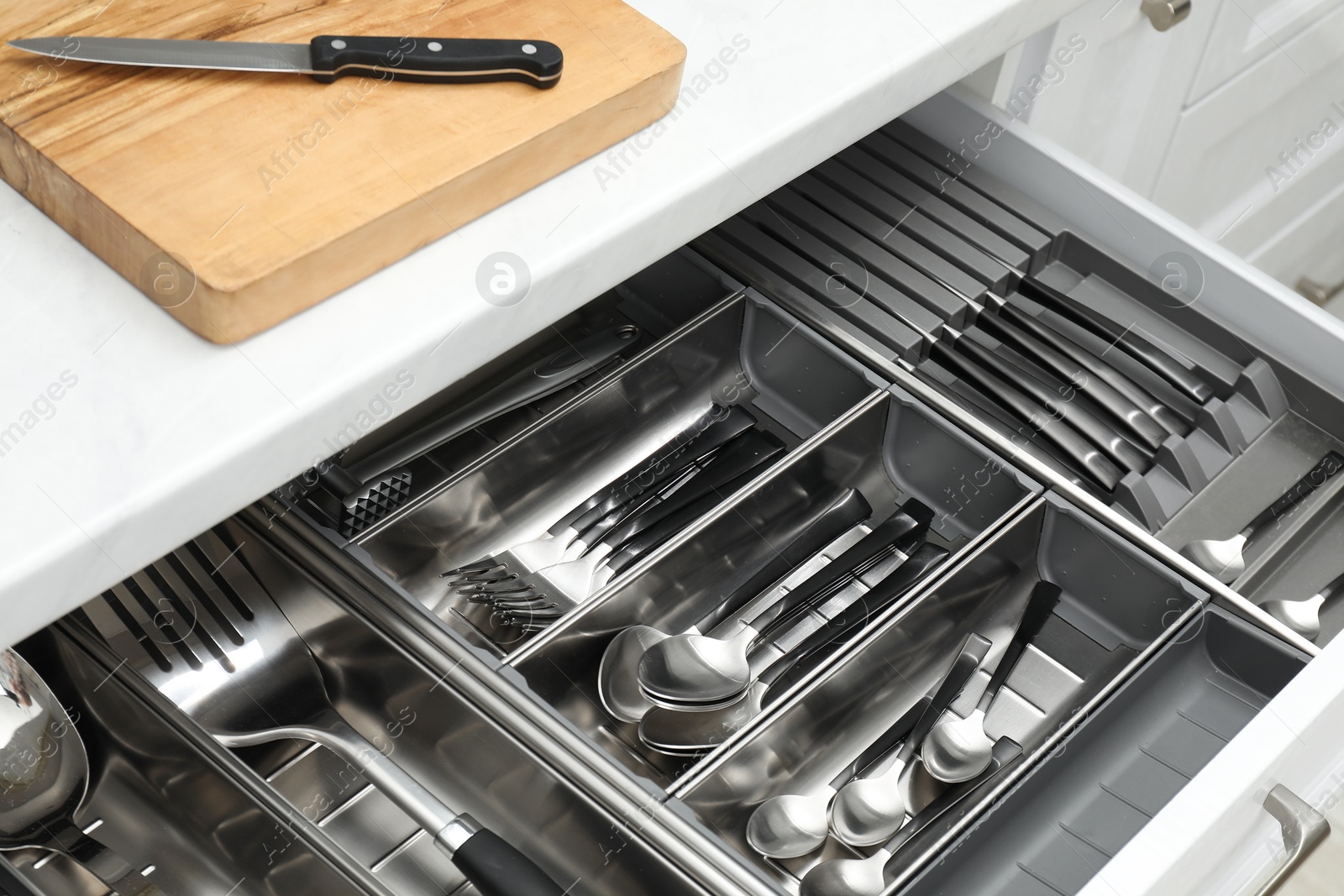 Photo of Box with cutlery in drawer, closeup. Kitchen utensils storage