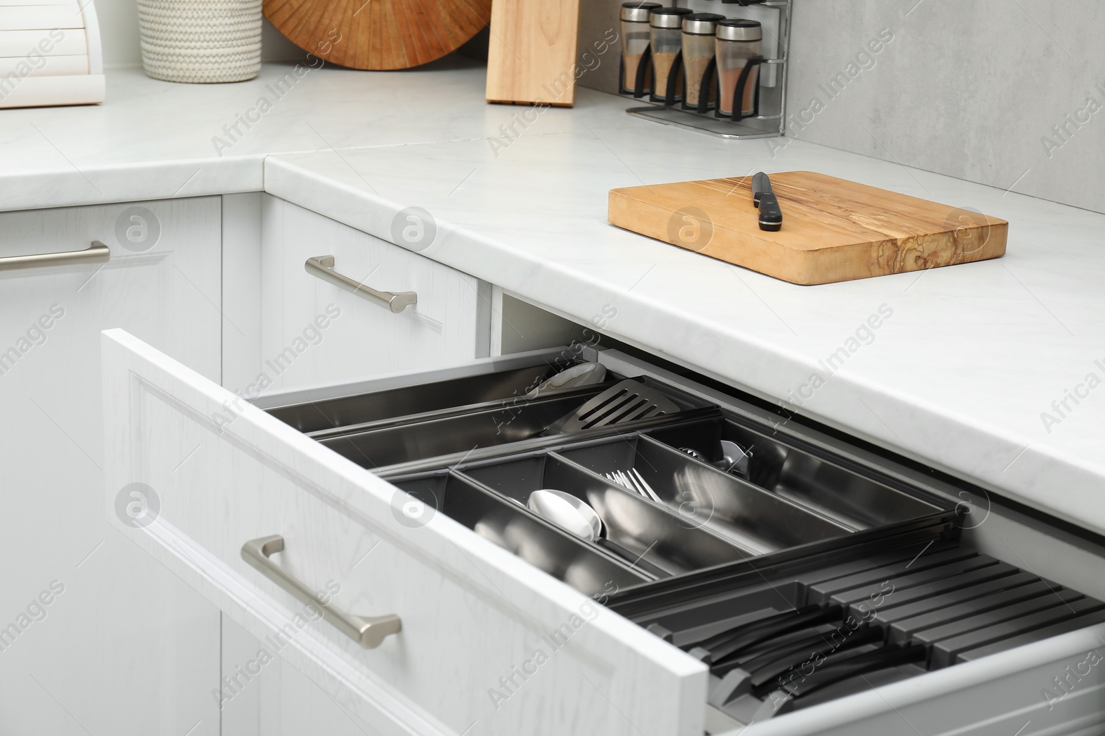 Photo of Box with cutlery in drawer indoors. Kitchen utensils storage