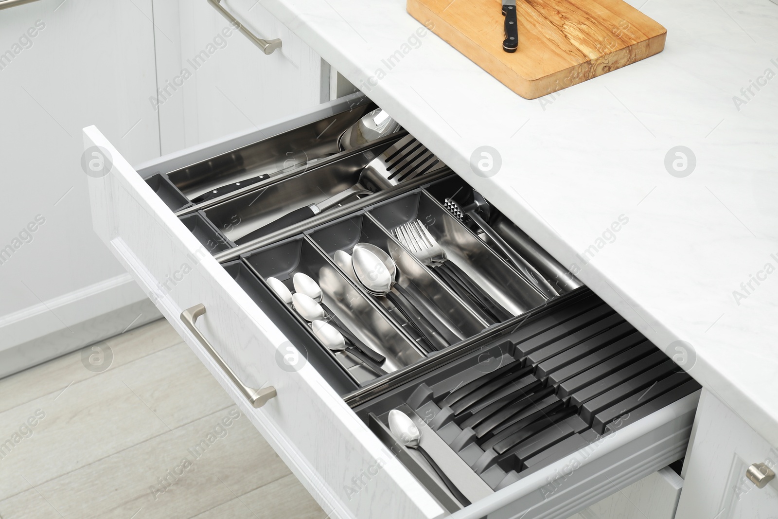 Photo of Box with cutlery in drawer indoors. Kitchen utensils storage