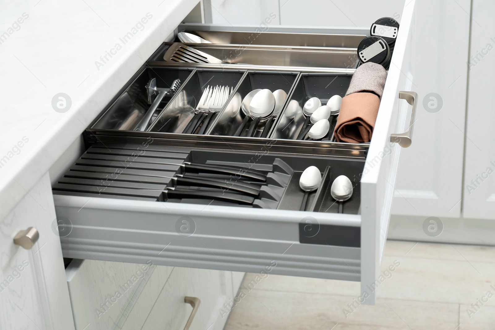 Photo of Box with cutlery in drawer indoors. Kitchen utensils storage