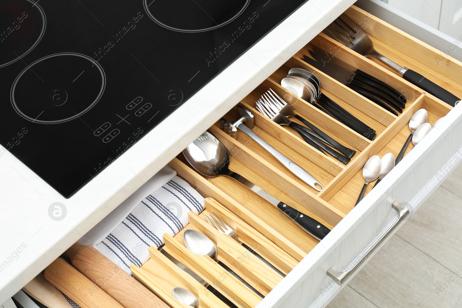 Photo of Box with cutlery in drawer, closeup. Kitchen utensils storage