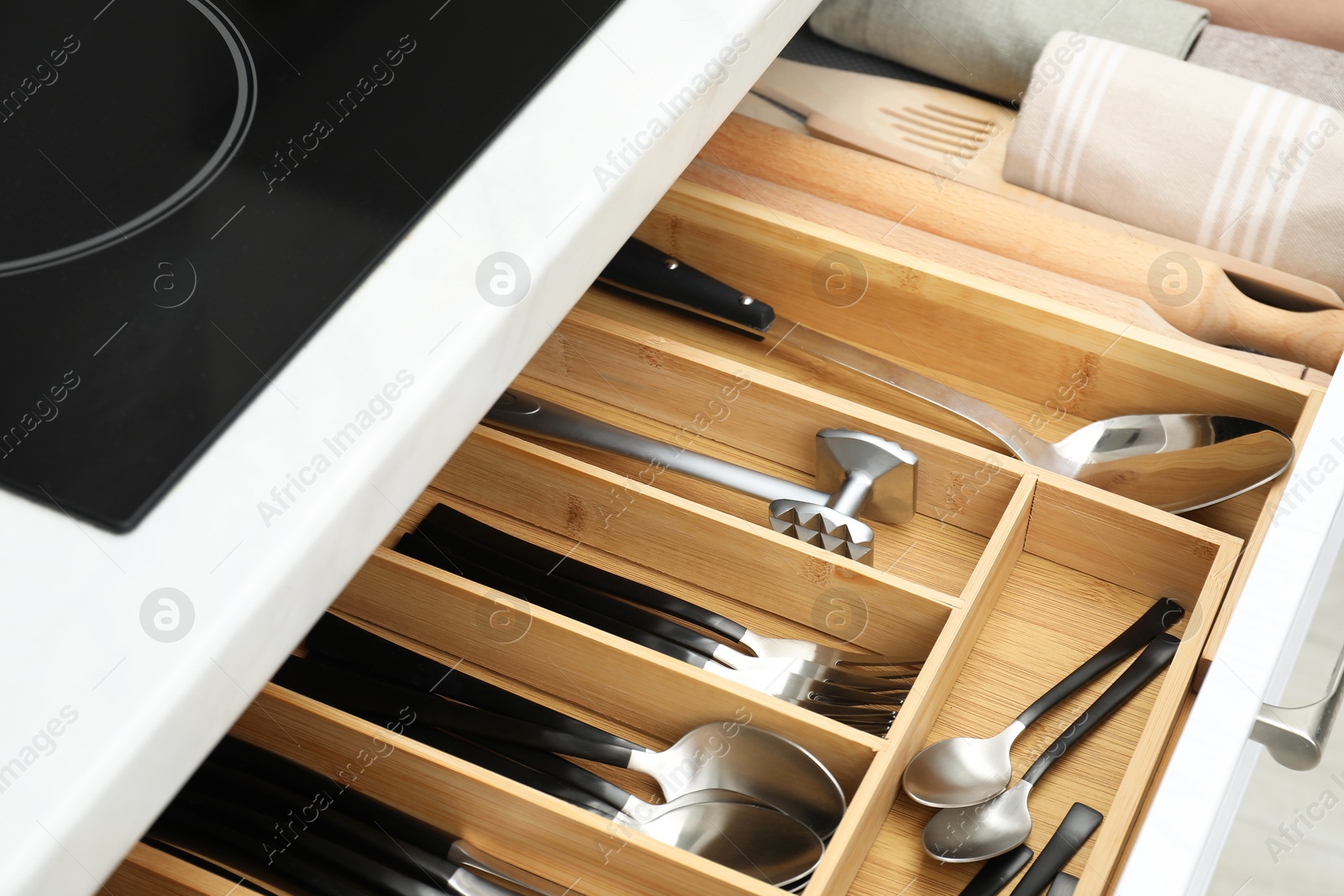 Photo of Box with cutlery in drawer, closeup. Kitchen utensils storage