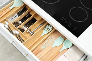 Photo of Box with cutlery in drawer, closeup. Kitchen utensils storage