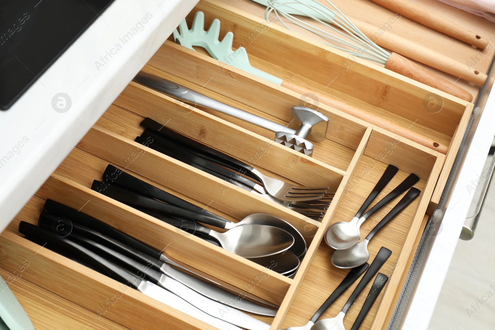 Photo of Box with cutlery in drawer, closeup. Kitchen utensils storage