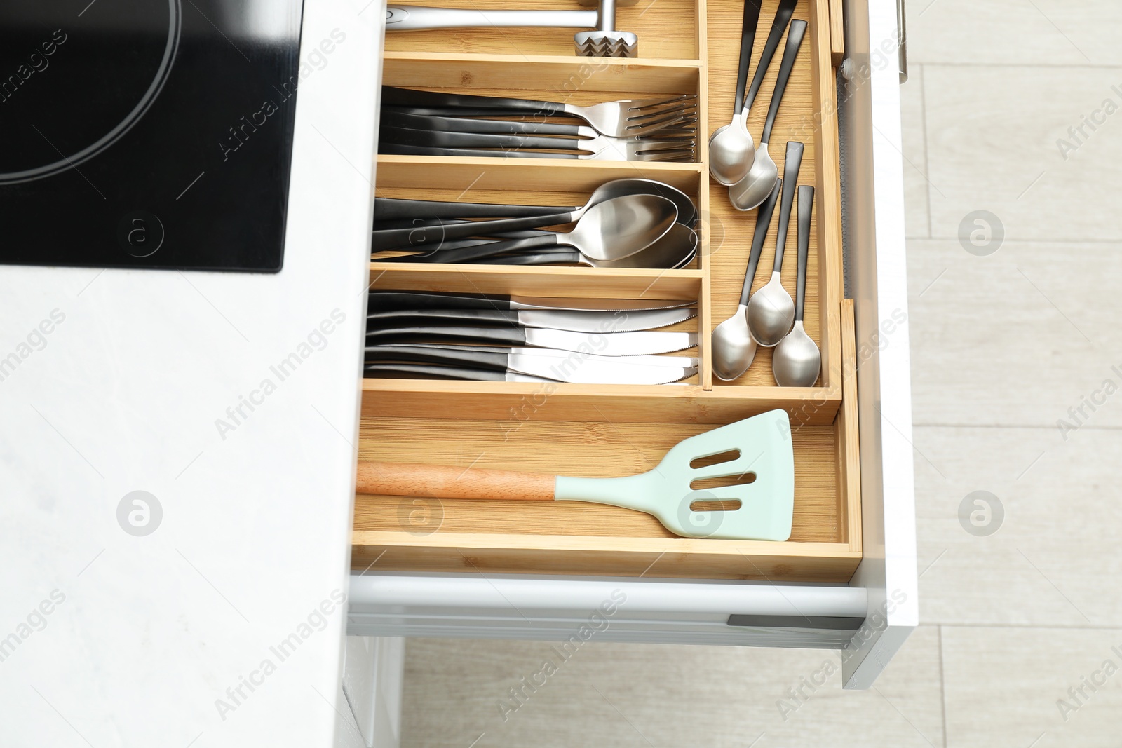 Photo of Box with cutlery in drawer, closeup. Kitchen utensils storage