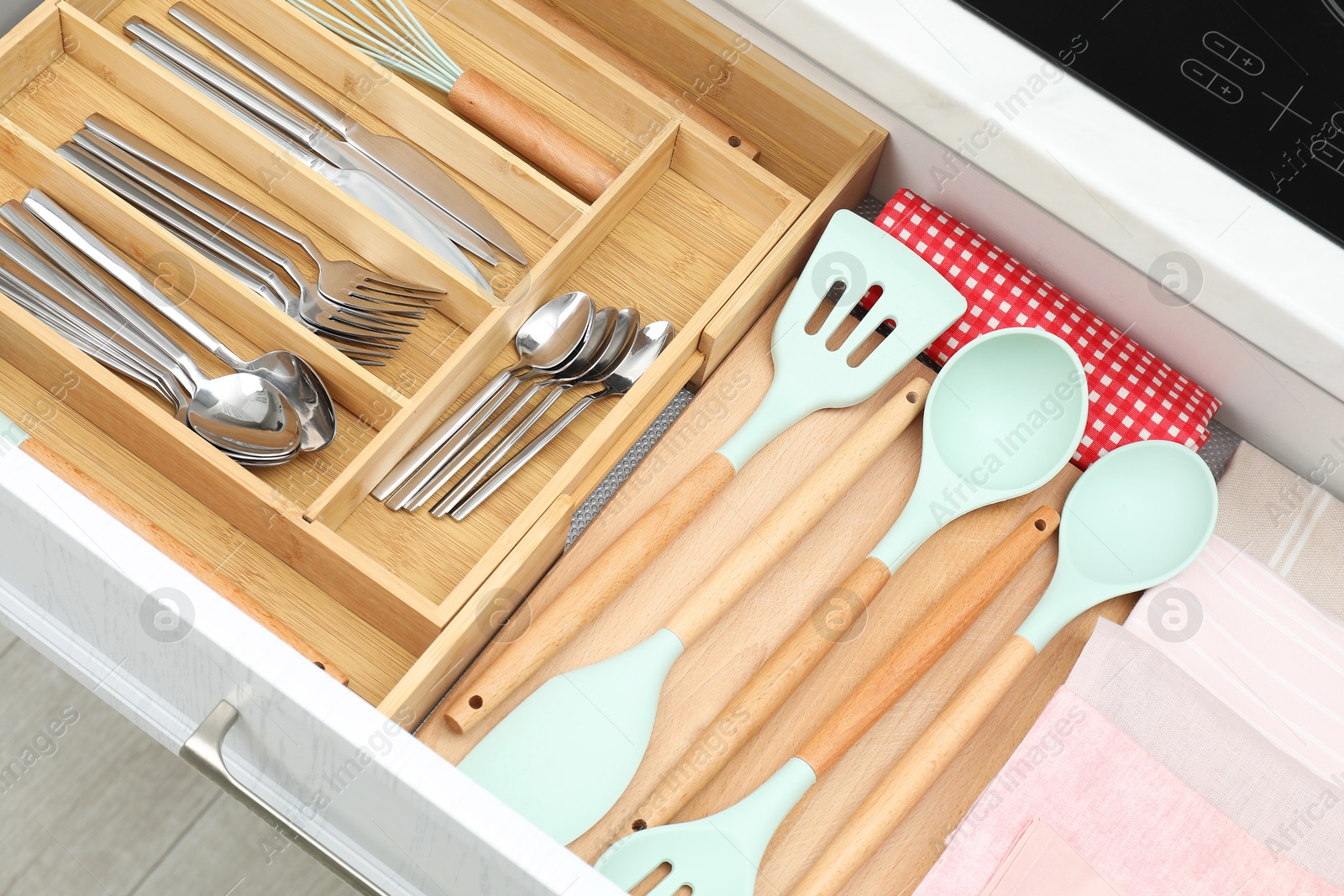 Photo of Box with cutlery in drawer, closeup. Kitchen utensils storage