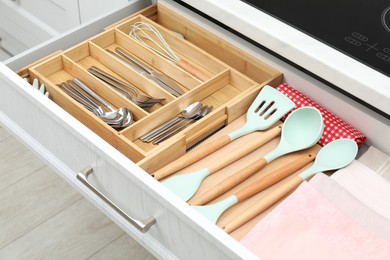 Photo of Box with cutlery in drawer, closeup. Kitchen utensils storage