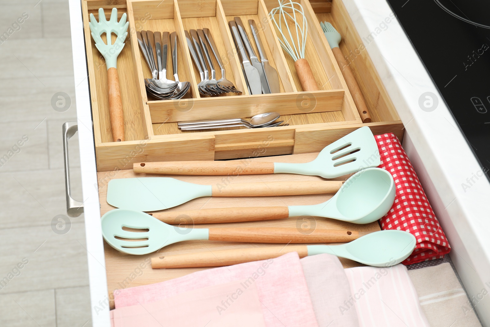 Photo of Box with cutlery in drawer, closeup. Kitchen utensils storage