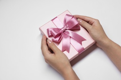 Photo of Woman holding gift box with bow on white background, closeup