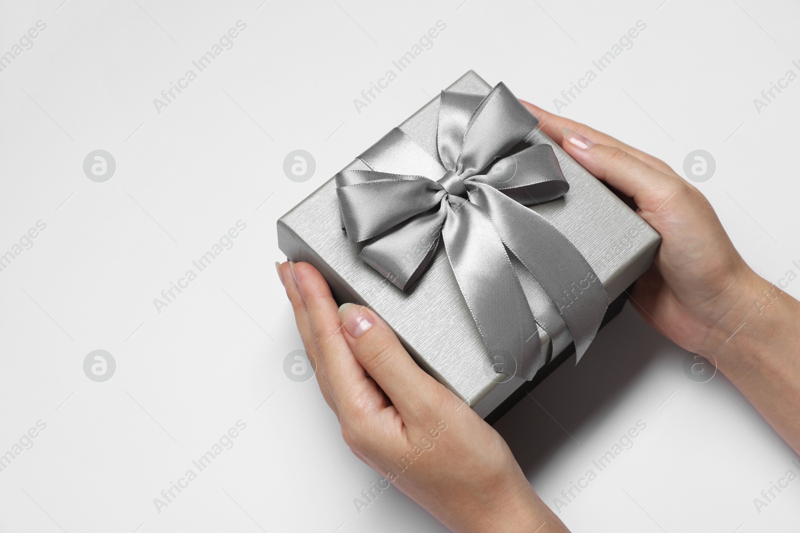 Photo of Woman holding gift box with bow on white background, closeup