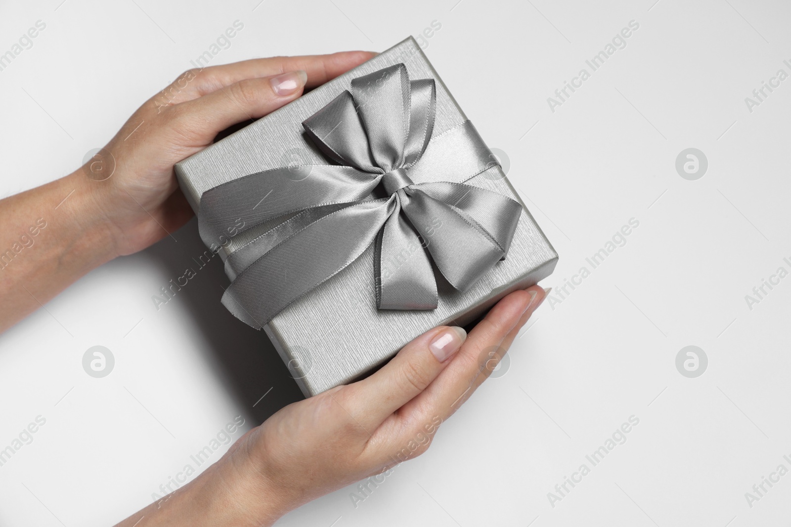 Photo of Woman holding gift box with bow on white background, closeup