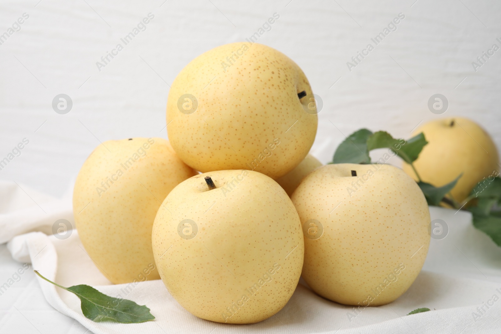 Photo of Delicious fresh apple pears and green leaves on table, closeup