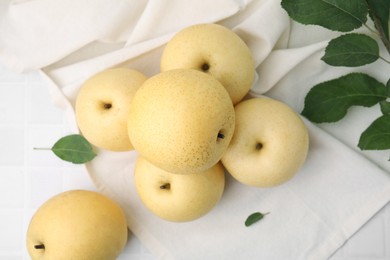 Photo of Delicious fresh apple pears and green leaves on white table, top view