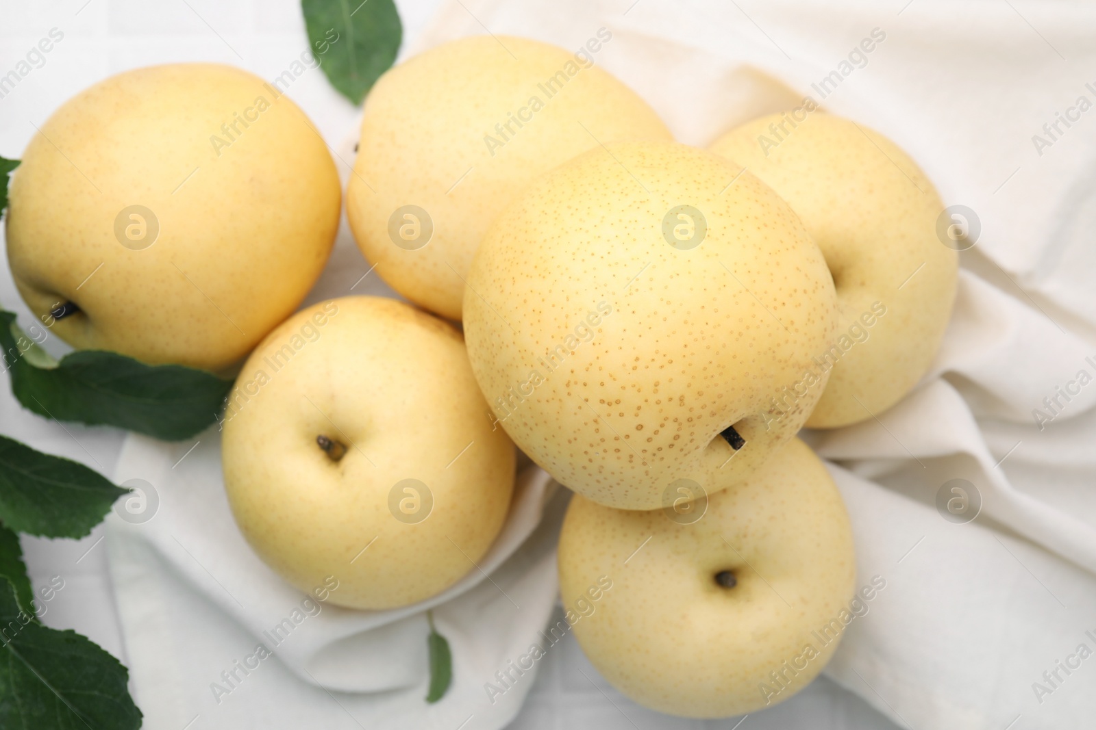 Photo of Delicious fresh apple pears and green leaves on table, closeup