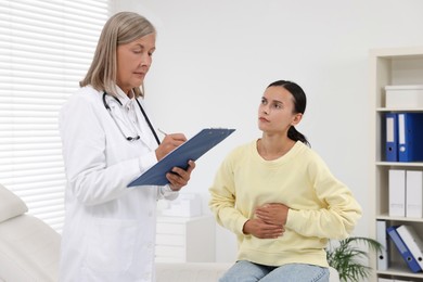 Photo of Senior doctor consulting patient with stomach pain in hospital