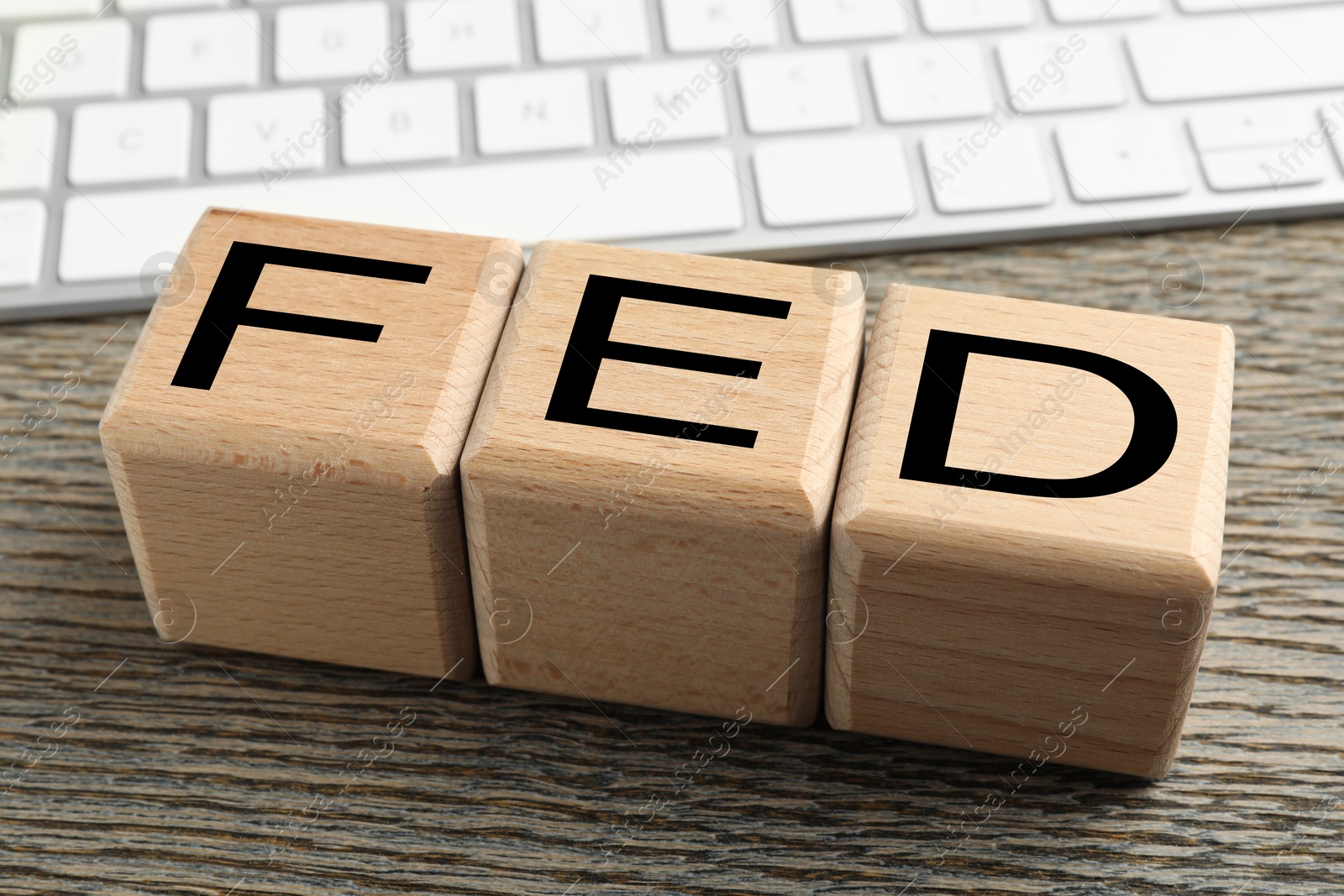 Photo of Cubes with letters Fed (Federal Reserve System) and keyboard on wooden table