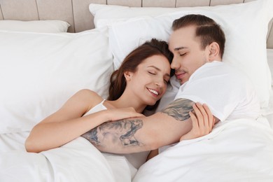 Happy couple lying on bed at home