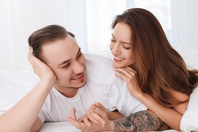 Happy couple spending time together on bed at home