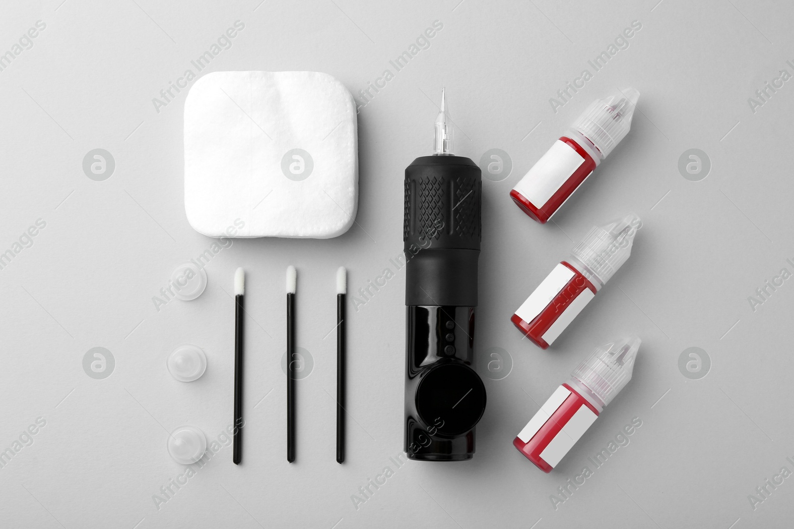 Photo of Permanent makeup equipment kit on light grey background, flat lay