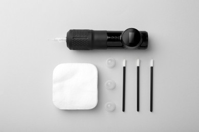 Photo of Permanent makeup equipment kit on light grey background, flat lay