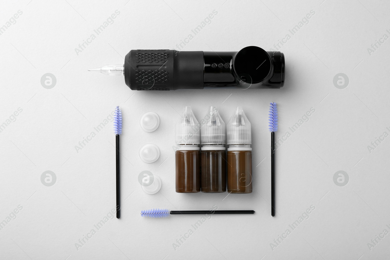 Photo of Permanent makeup equipment kit on light grey background, flat lay