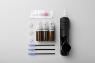 Photo of Permanent makeup equipment kit on light grey background, flat lay