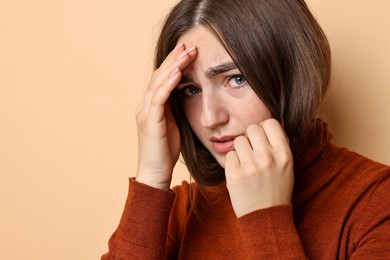 Photo of Portrait of scared woman on beige background