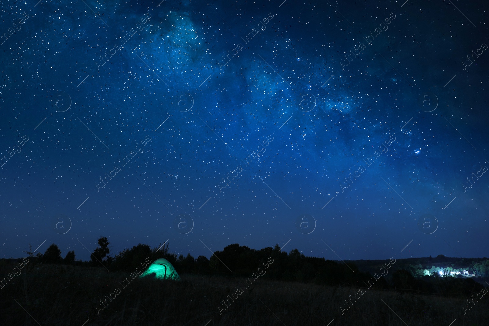 Photo of Modern camping tent in wilderness at night, slow shutter speed effect