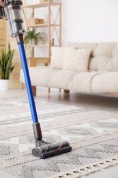 Photo of Cleaning with wireless handheld vacuum cleaner indoors, closeup