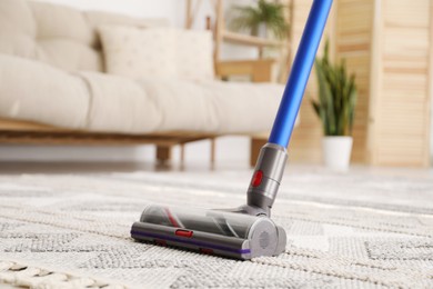 Photo of Cleaning with wireless handheld vacuum cleaner indoors, closeup