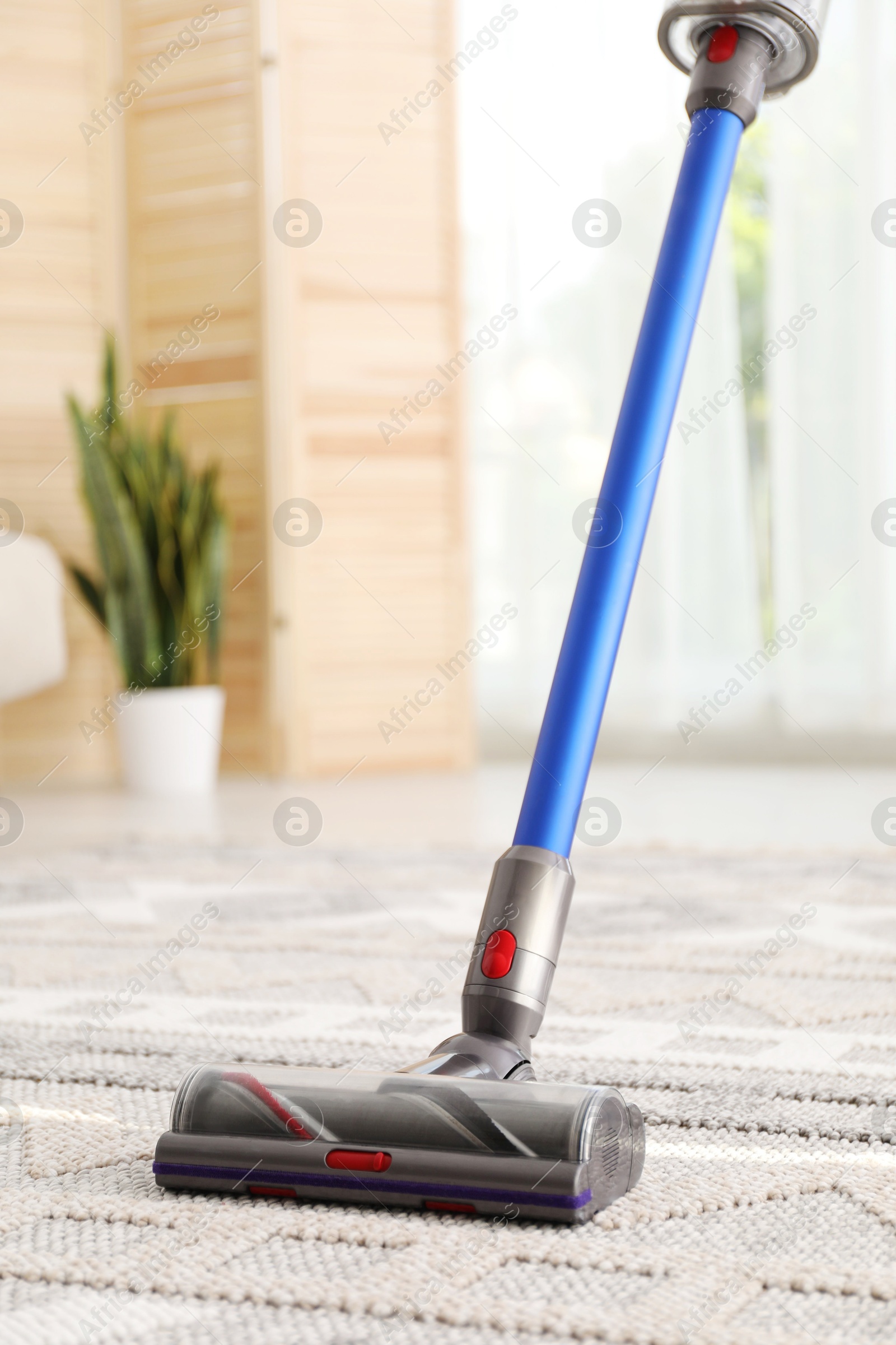 Photo of Cleaning with wireless handheld vacuum cleaner indoors, closeup