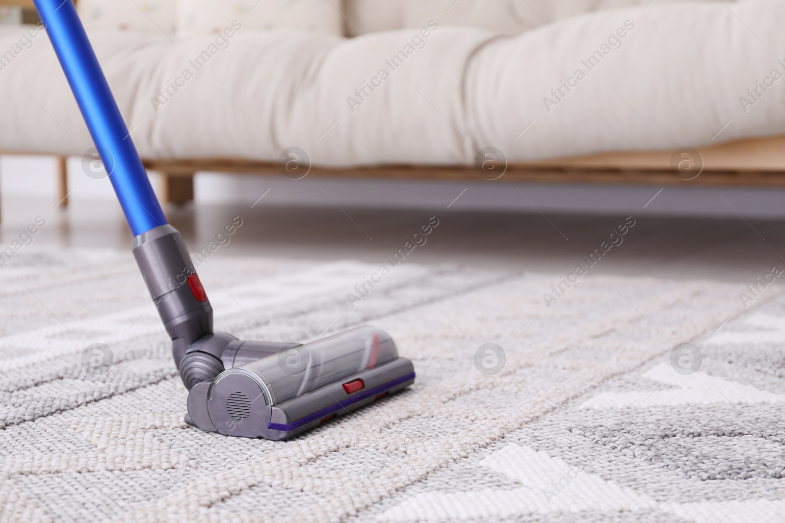 Photo of Cleaning with wireless handheld vacuum cleaner indoors, closeup