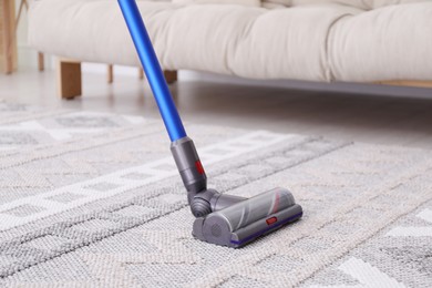 Photo of Cleaning with wireless handheld vacuum cleaner indoors, closeup