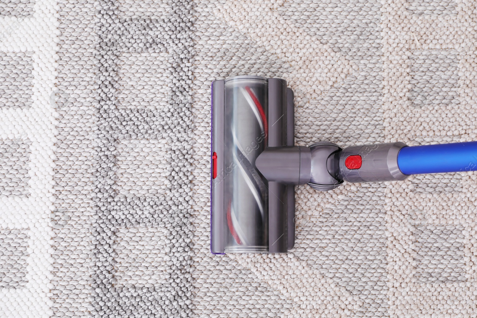 Photo of Cleaning rug with wireless handheld vacuum, top view