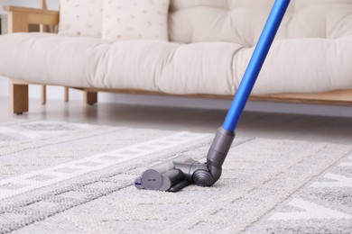 Photo of Cleaning with wireless handheld vacuum cleaner indoors, closeup