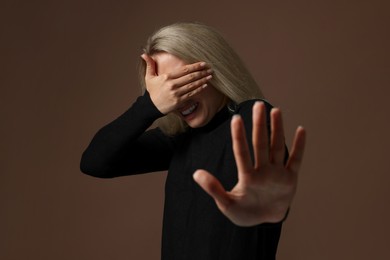 Portrait of scared woman on brown background