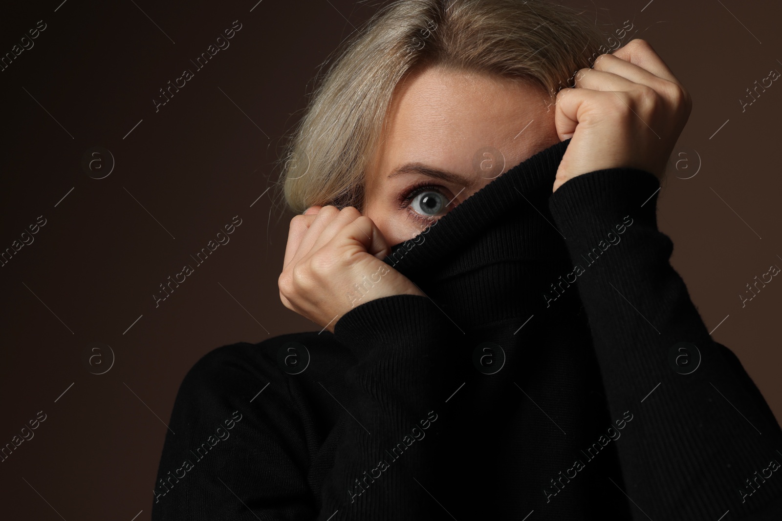 Photo of Portrait of scared woman on brown background