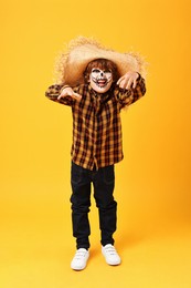 Photo of Funny boy dressed like scarecrow on yellow background. Halloween celebration