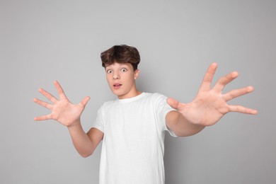 Photo of Portrait of scared teenage boy on grey background