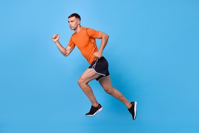 Photo of Man in sportswear running on light blue background