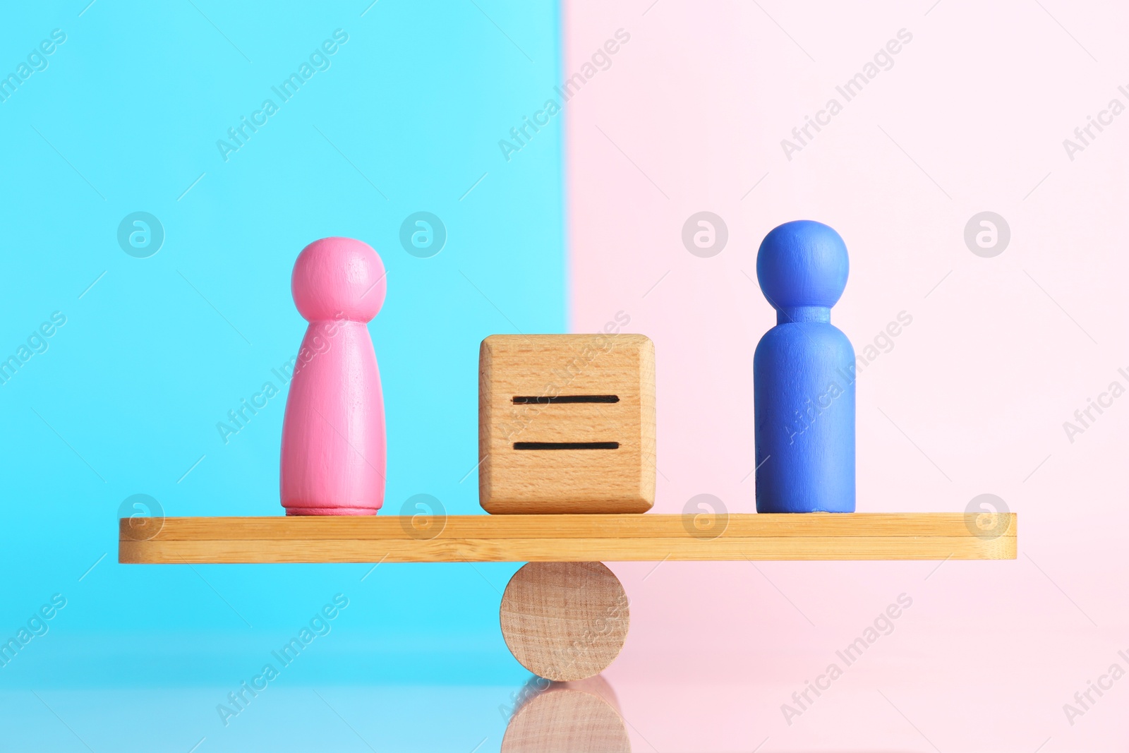 Photo of Gender equality concept. Cube with equals sign between male and female figures on scales against color background